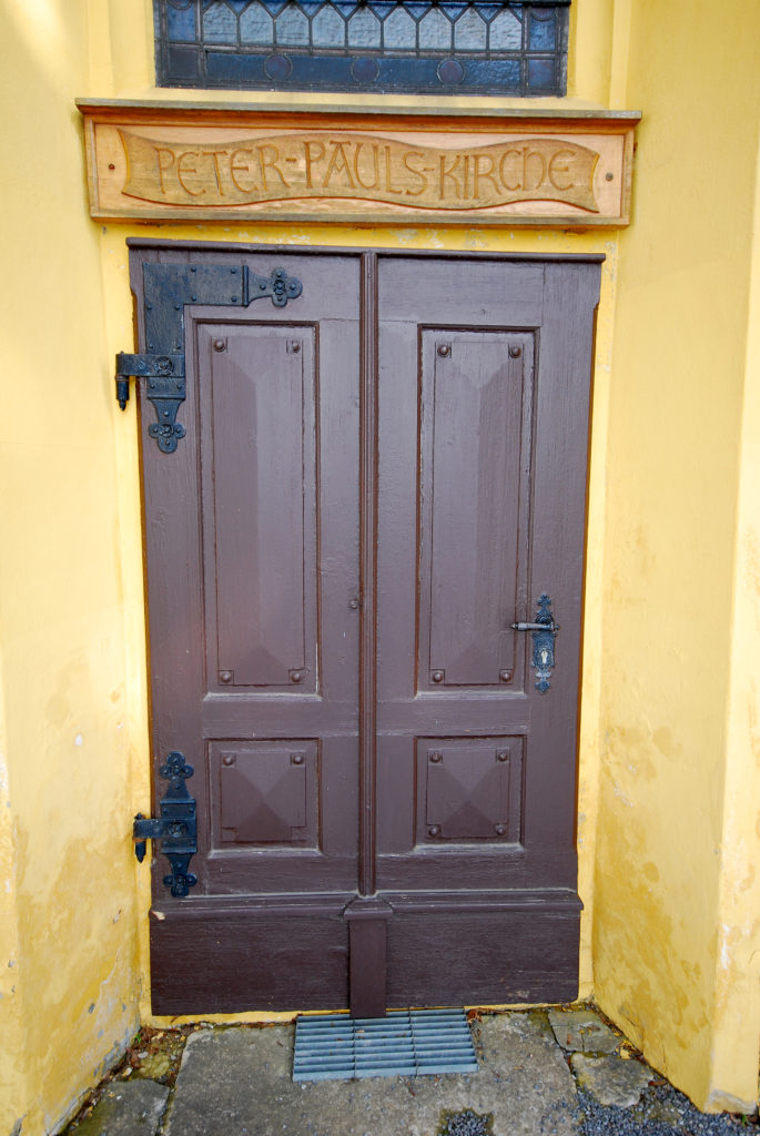 Kirche Hallbach - Eingangstür mit Namenszug "Peter-Pauls-Kirche"
